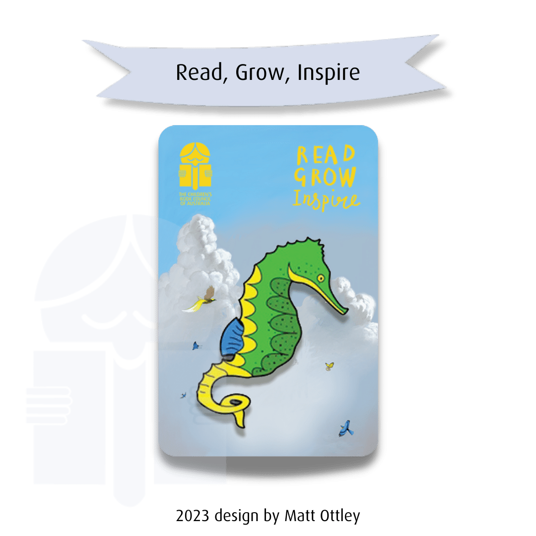 A picture of a brooch in the shape of a seahorse. Text on a graphic flag reads "Read, grow, inspire". Text at the base of the image says "2023 design by Matt Ottley".