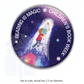 A round button badge with the profile of a young child with their face hidden by the cover of a book they are reading, flying upward into space, surrounded by a glowing light. Text circling the edge of the badge reads Reading is Magic, Children's Book Week®