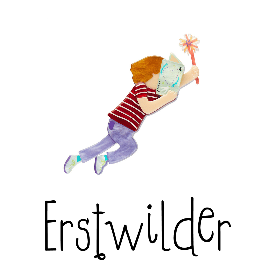 The photo of the front of small brooch which is a child in profile covering their face with an open book, their other hand outstretched holding a wand. The Erstwilder logo is below it. 