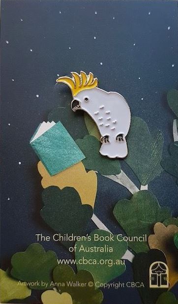 A photograph of a hat pin in the shape of a Cockatoo on a card with text that reads The Children's Book Council of Australia